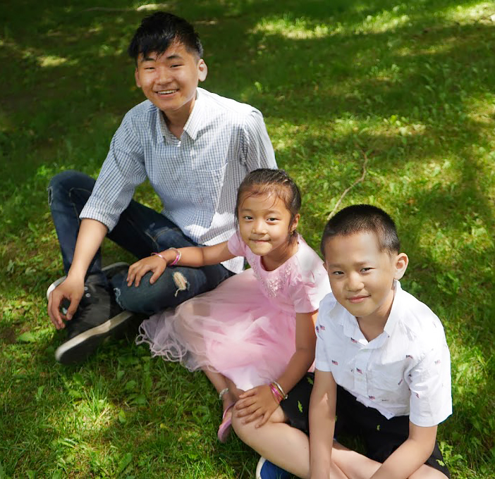 Three children sitting on grass