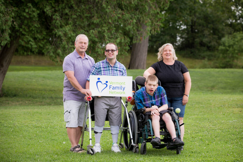 Parents with their two sons in walkers holding a sign that reads Vermont Family Network.